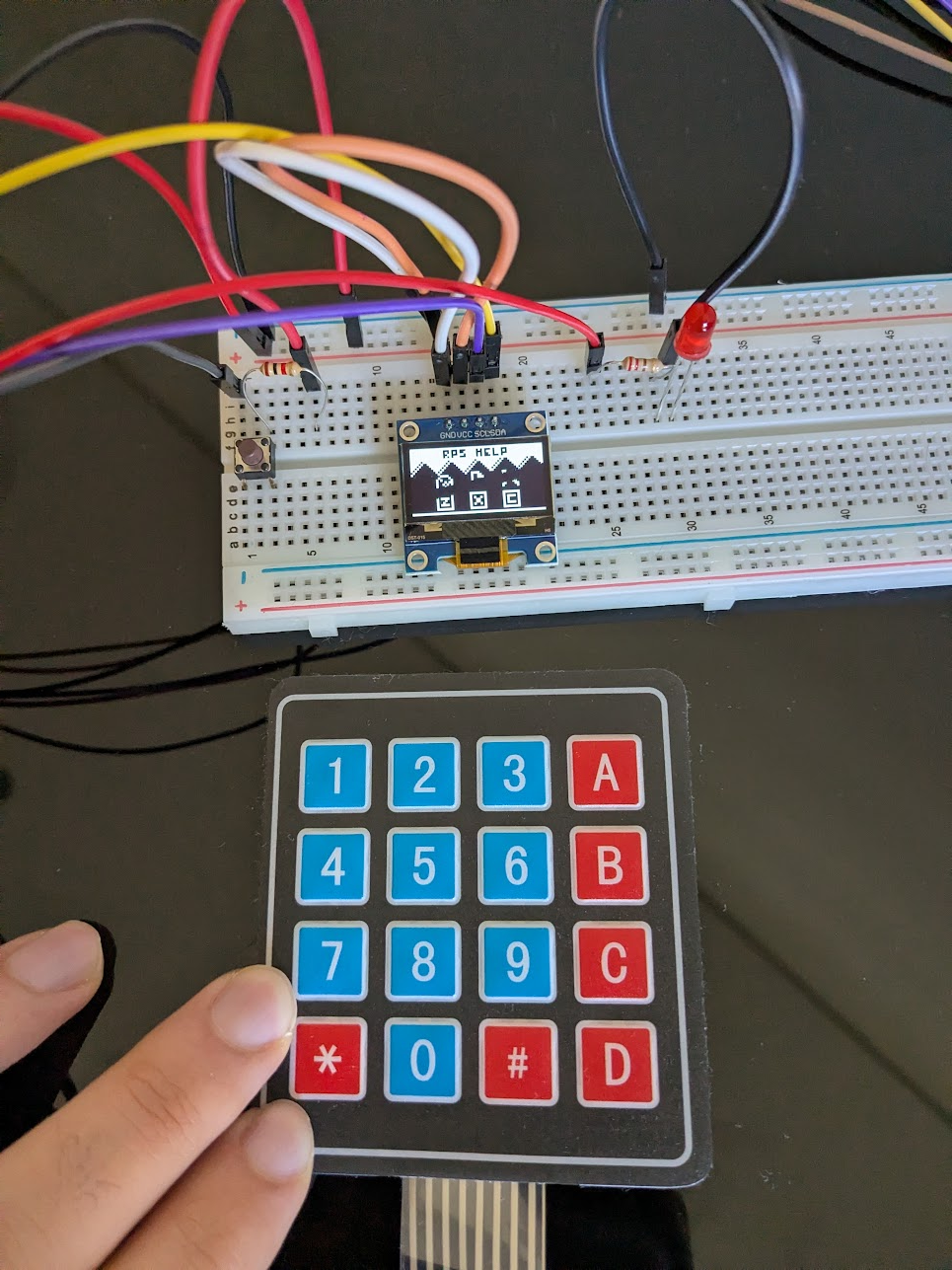 A small led screen showing a Chip-8 rock paper scissors game, alognside a 4x4 button keypad